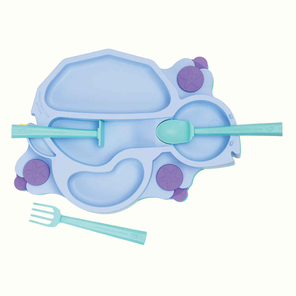 Image of the blue Turtle Training Plate and Utensils. The utensils are seafoam green. The pusher and spoon are located on their designated spots on the plate and the fork is in front of the plate.